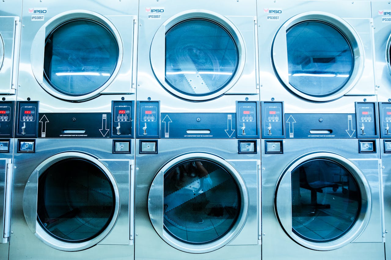 A row of modern washing machines in a launderette, showcasing contemporary laundry technology.